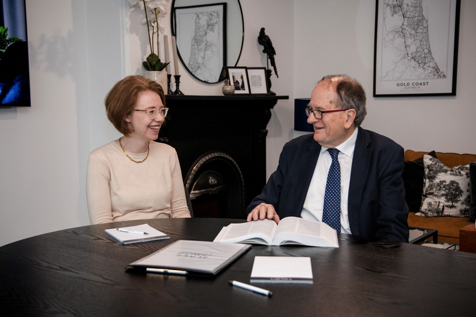 Woman and Man Seated at a Table, Smiling.  They Are in an Office Setting, With Documents and a Book Visible — Slack-Smith Partners In Moree, NSW