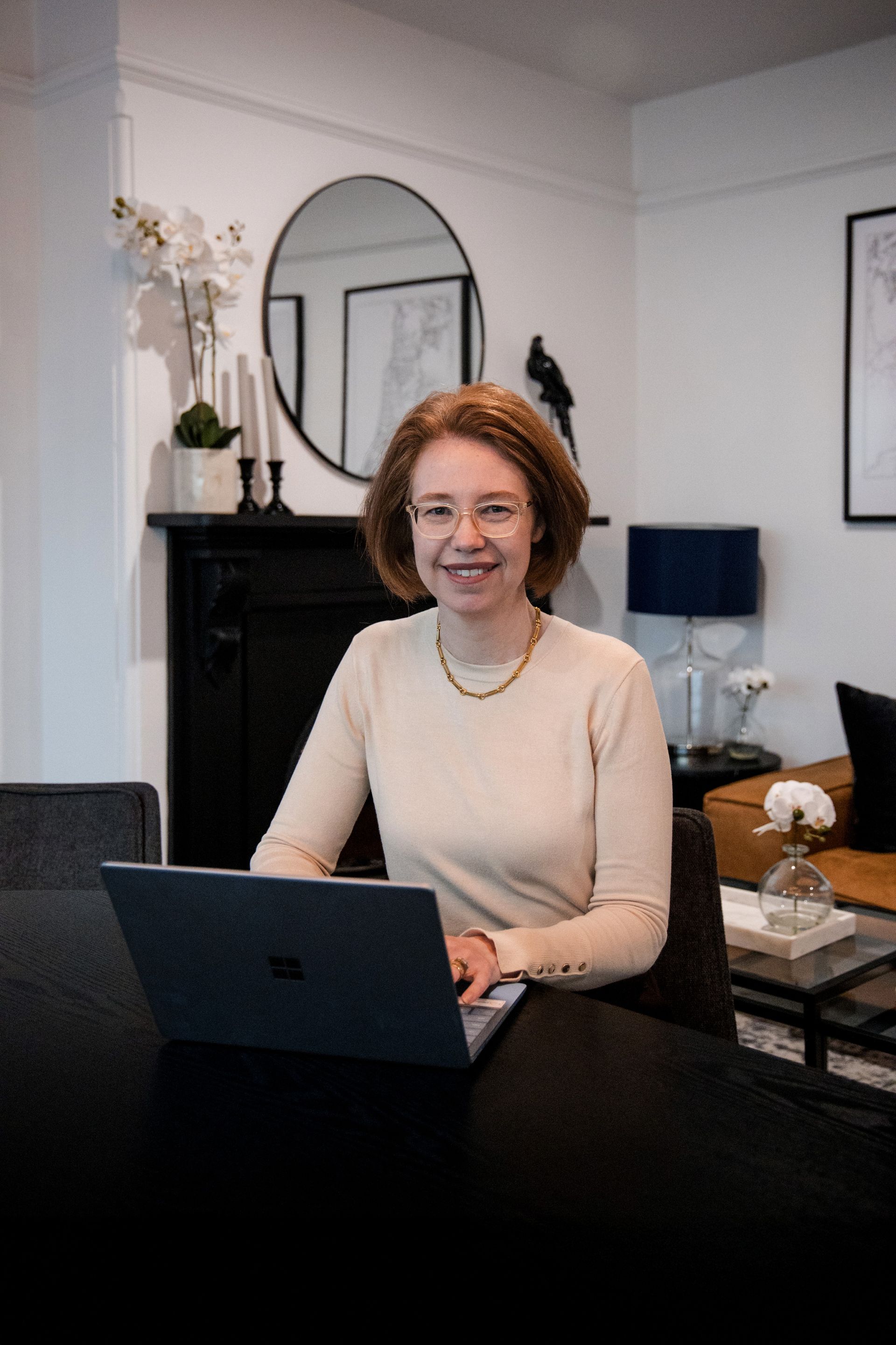 Woman in Glasses at a Table With Laptop, Smiling. Sitting in a Modern Home Office Setting — Slack-Smith Partners  in Punjab, India