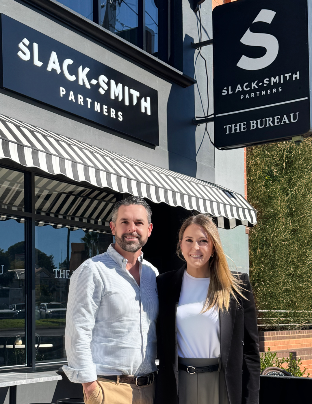 A Man and A Woman Are Standing in Front of A Building — Slack-Smith Partners in Tamworth, NSW