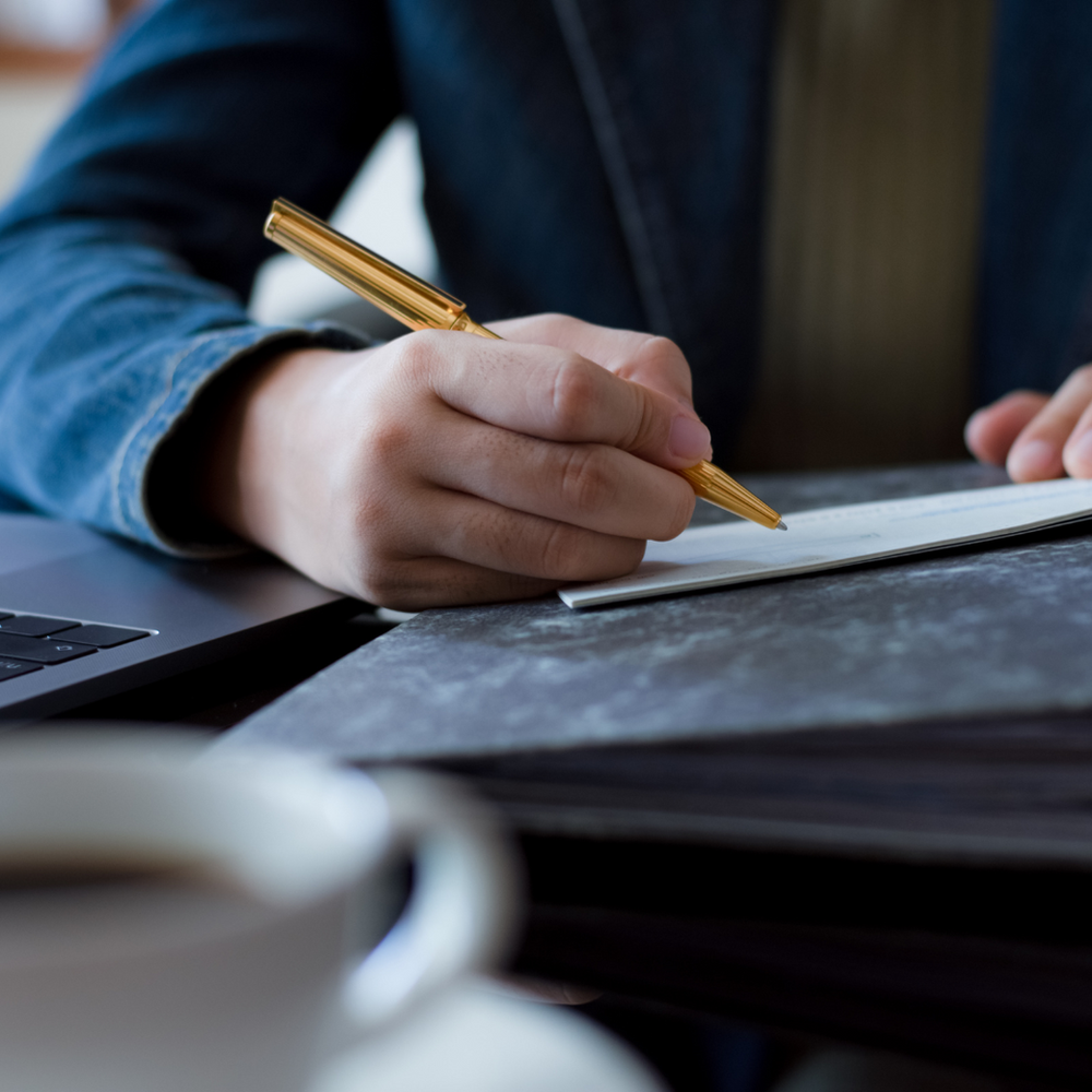 A Person is Writing on A Piece of Paper With A Pen — Slack-Smith Partners in Tamworth, NSW