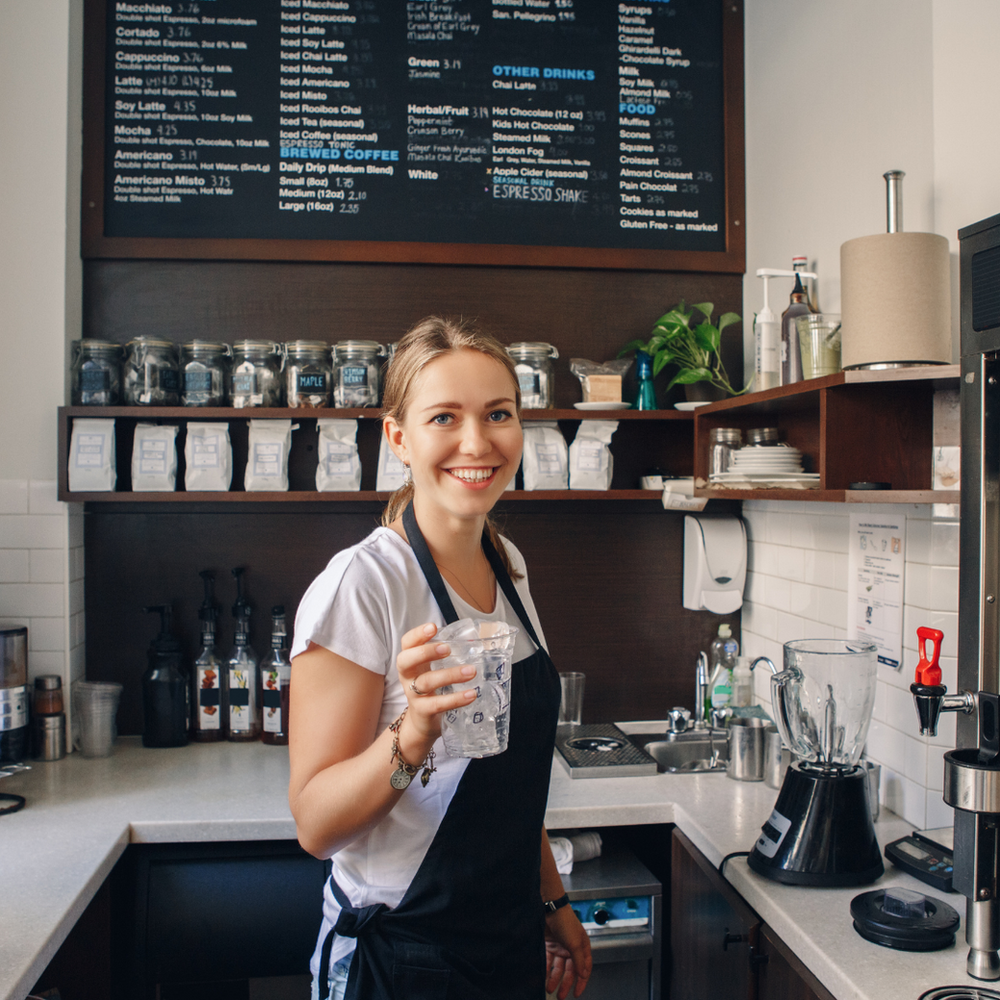 A Woman Standing in A Kitchen Holding a Glass of Water — Slack-Smith Partners in Tamworth, NSW