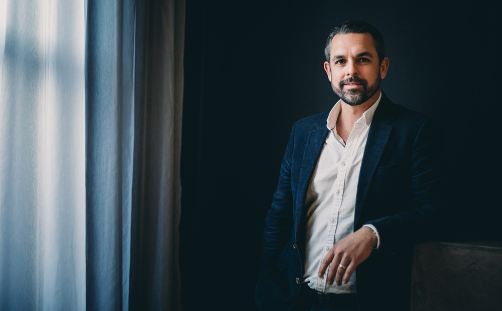 A Man in A Suit and White Shirt Is Standing in Front of A Window — Slack-Smith Partners in Tamworth, NSW