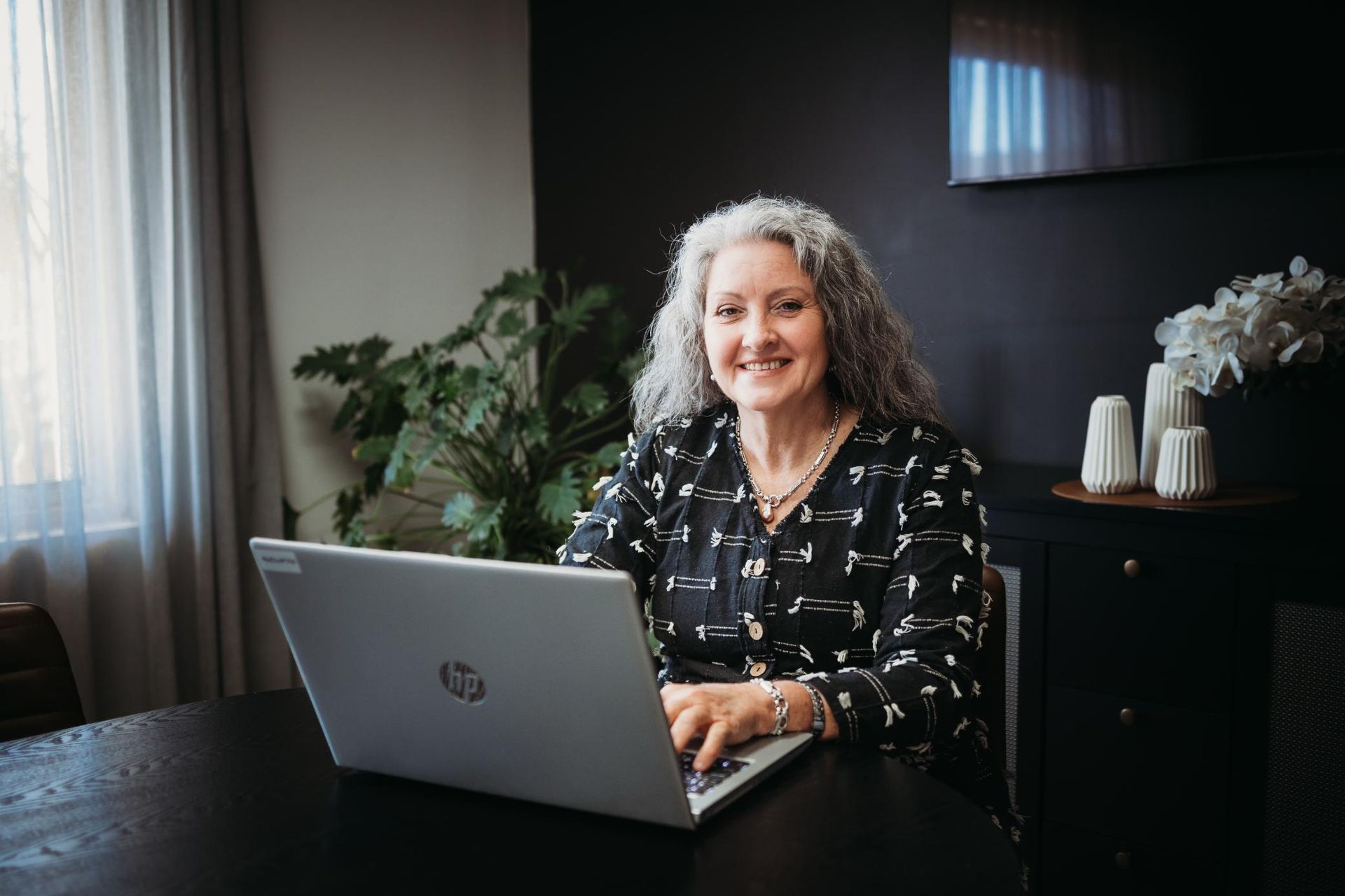 Woman is Sitting at a Table Using a Laptop Computer — Slack-Smith Partners In Moree, NSW