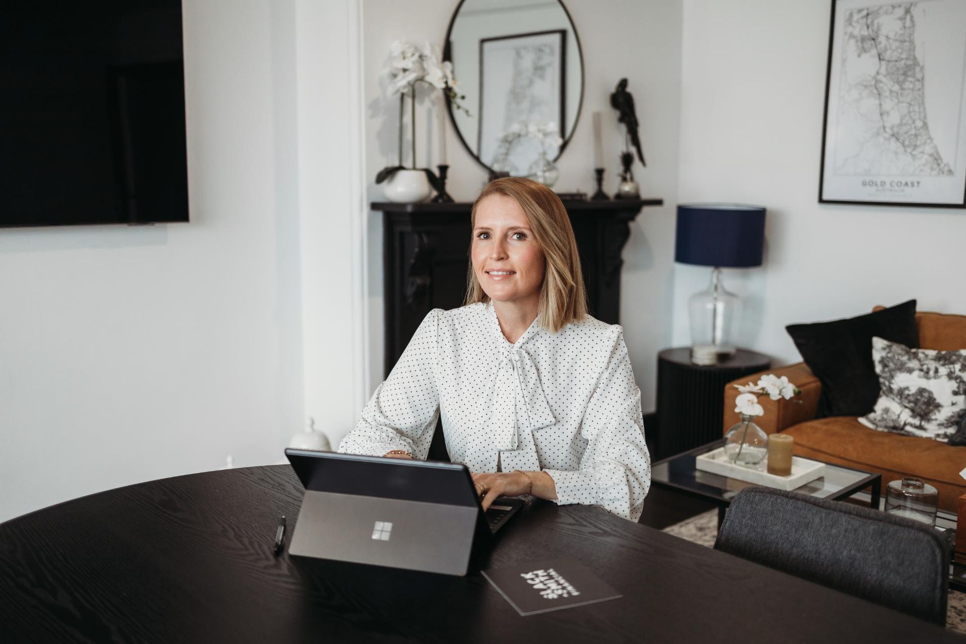 A Woman Is Sitting at A Table Using a Laptop Computer — Slack-Smith Partners in Tamworth, NSW