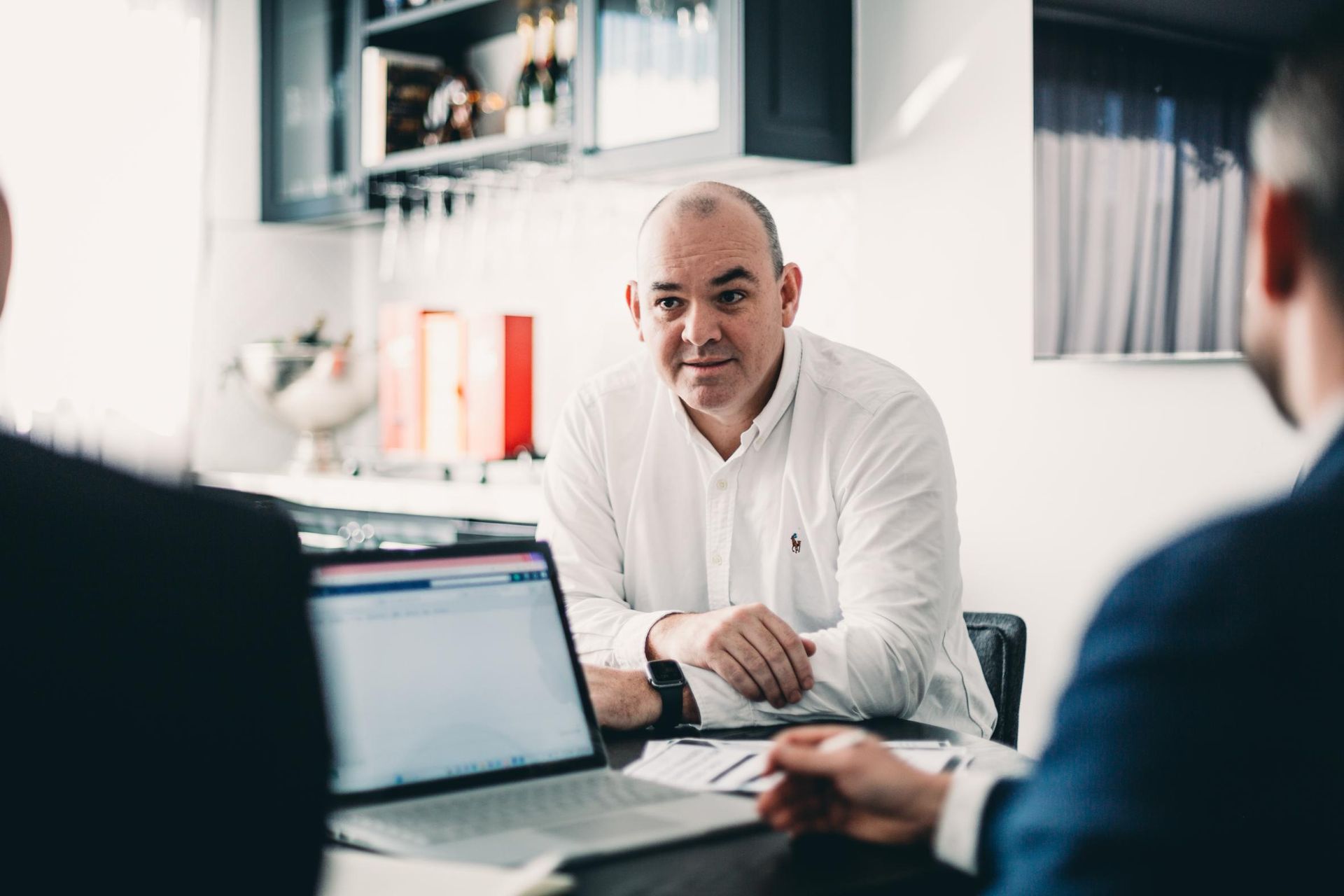 A Group of Men Are Sitting at A Table with Laptops — Slack-Smith Partners in Tamworth, NSW