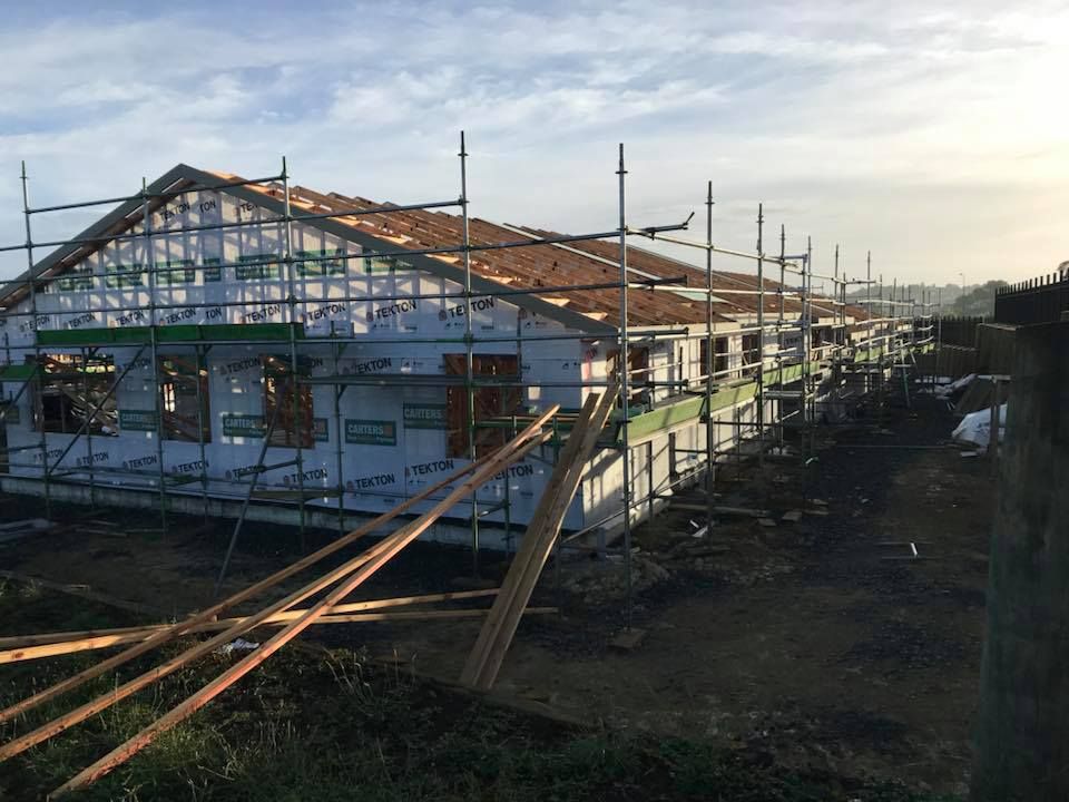 Building under construction with scaffolding and a partially completed roof.
