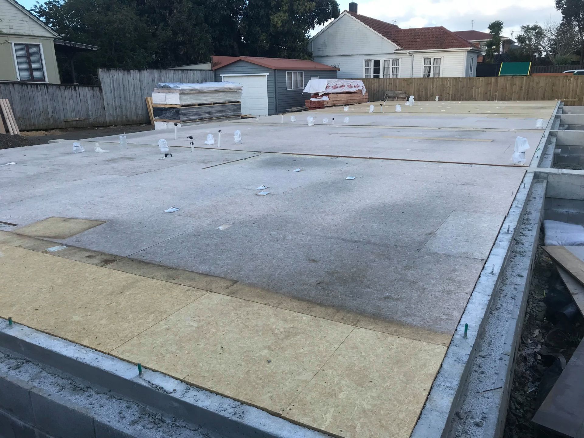 Concrete foundation slab with wood framing, construction site setting.
