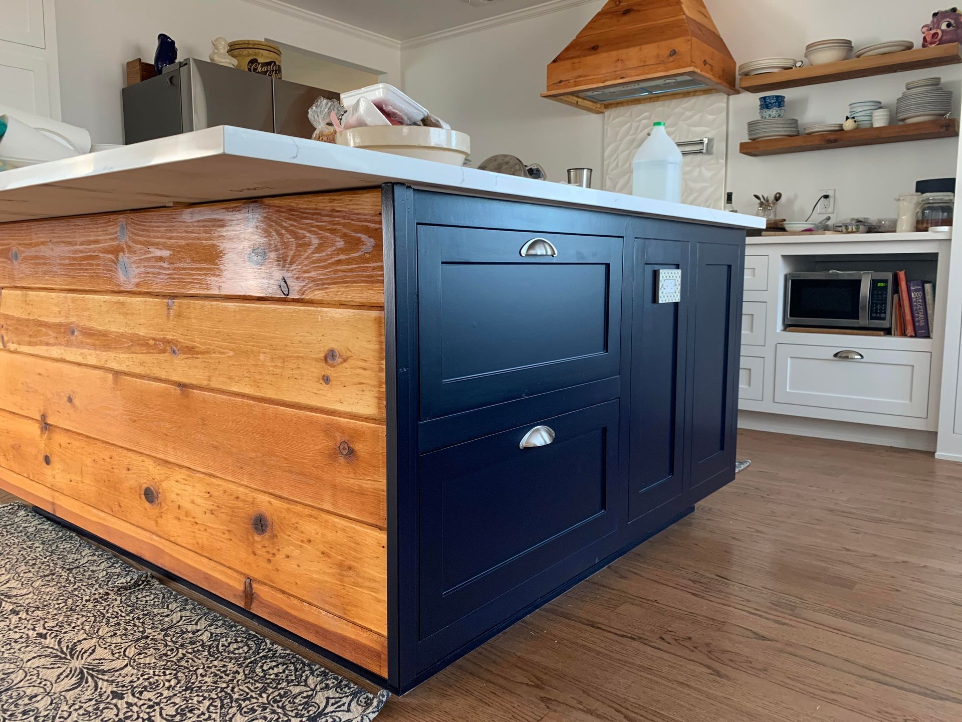 A kitchen with a wooden island and blue cabinets.