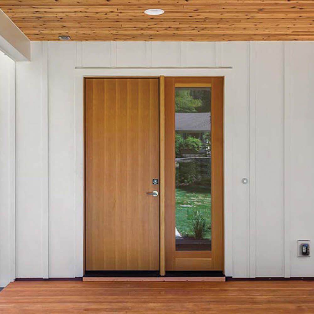 A wooden door with a glass window is in a room with a wooden floor.