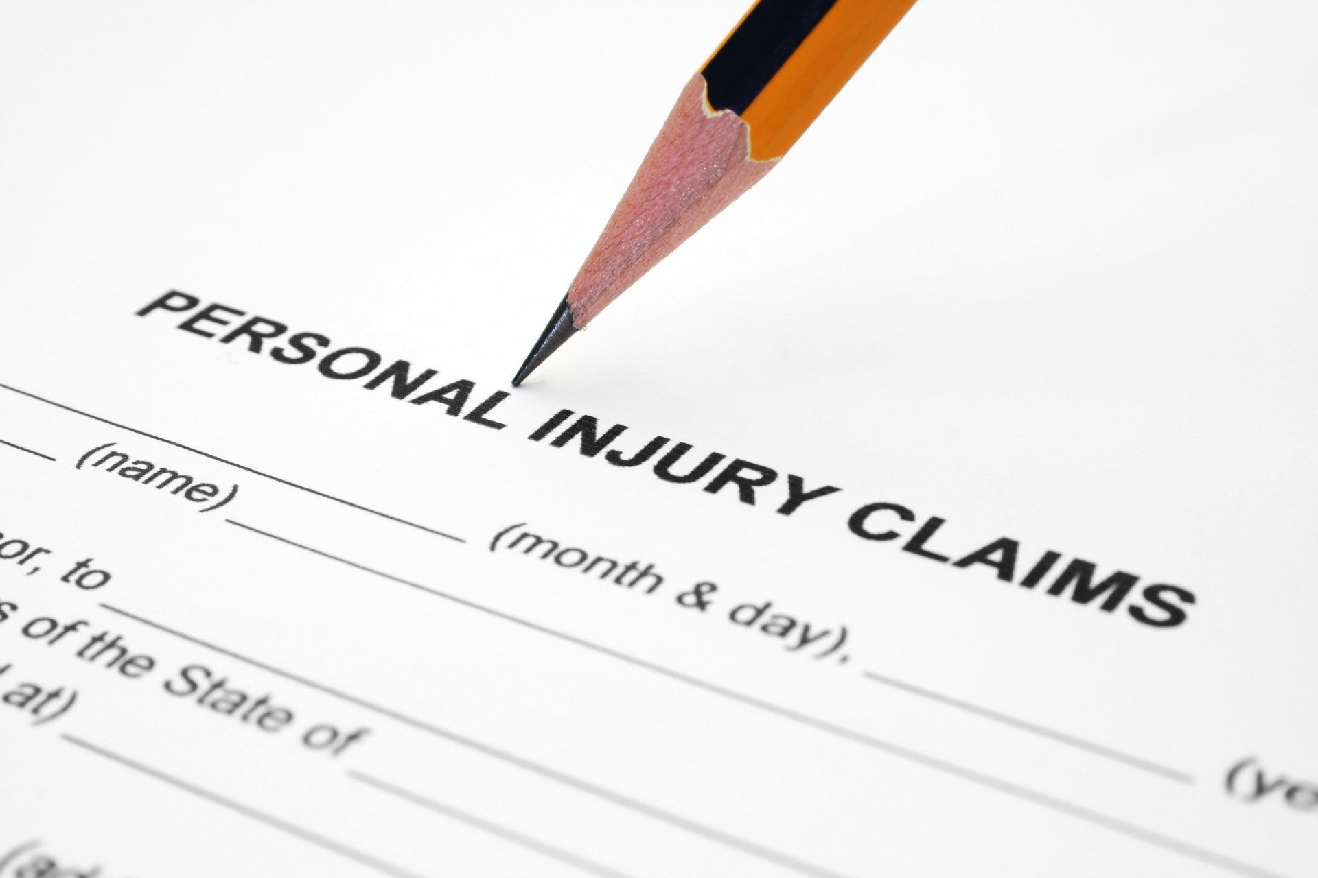 a pencil is writing on a personal injury claims form