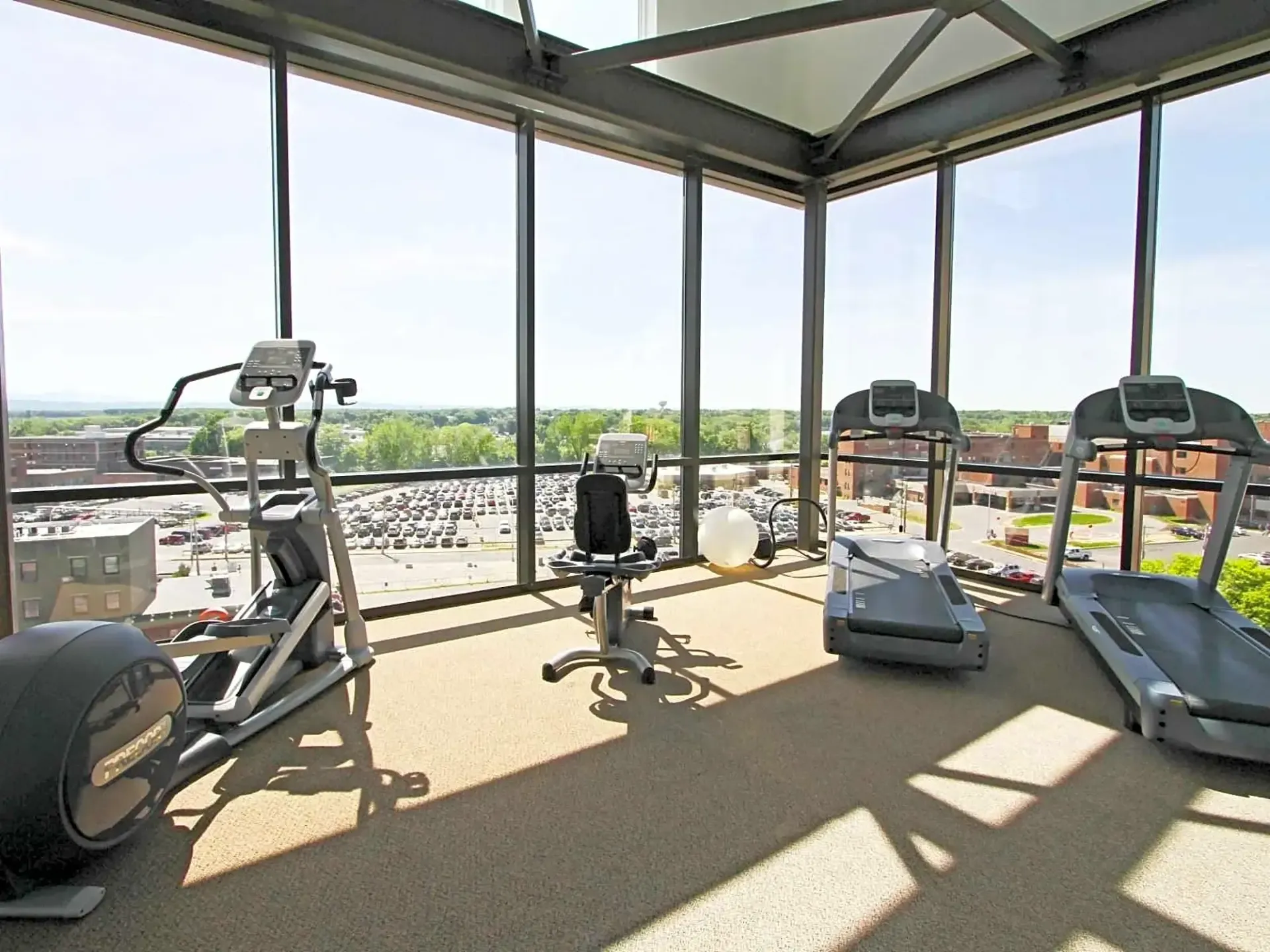 A gym with a lot of windows and exercise equipment