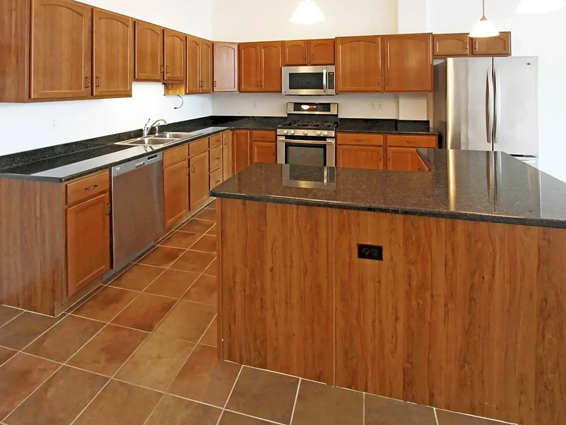A kitchen with stainless steel appliances and wooden cabinets
