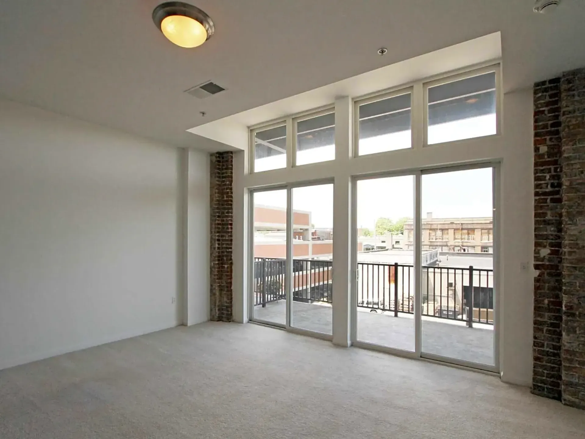 An empty room with lots of windows and a balcony