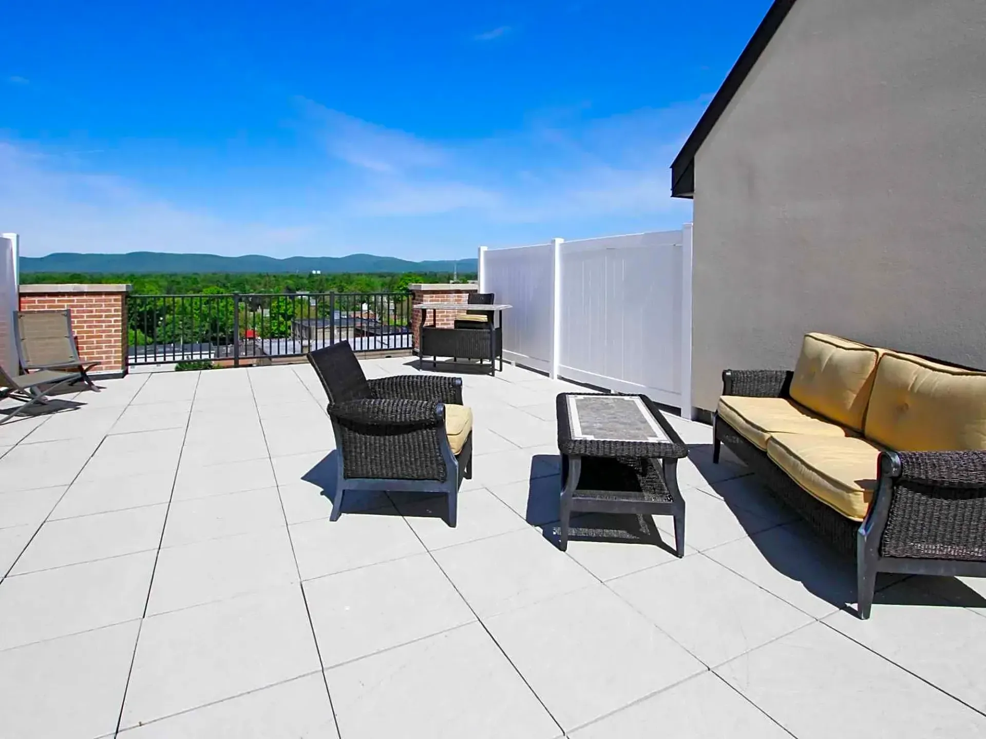 A patio with a couch , chairs and a table