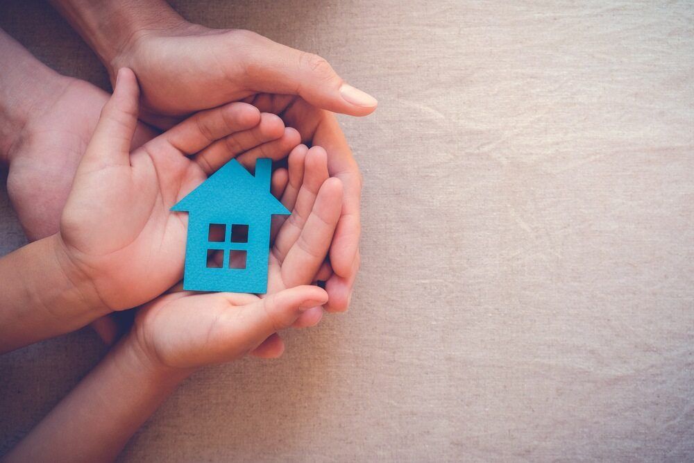 A Man and a Child Are Holding a Blue House in Their Hands — Murphy Finance Solutions–Darwin & Palmerston In Zuccoli, NT