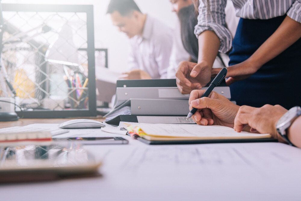A Group of People Are Sitting at a Table Working on a Project — Murphy Finance Solutions–Darwin & Palmerston In Zuccoli, NT