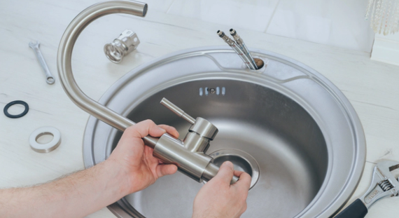 Electrician working on electrical panel in a wooden-framed wall.