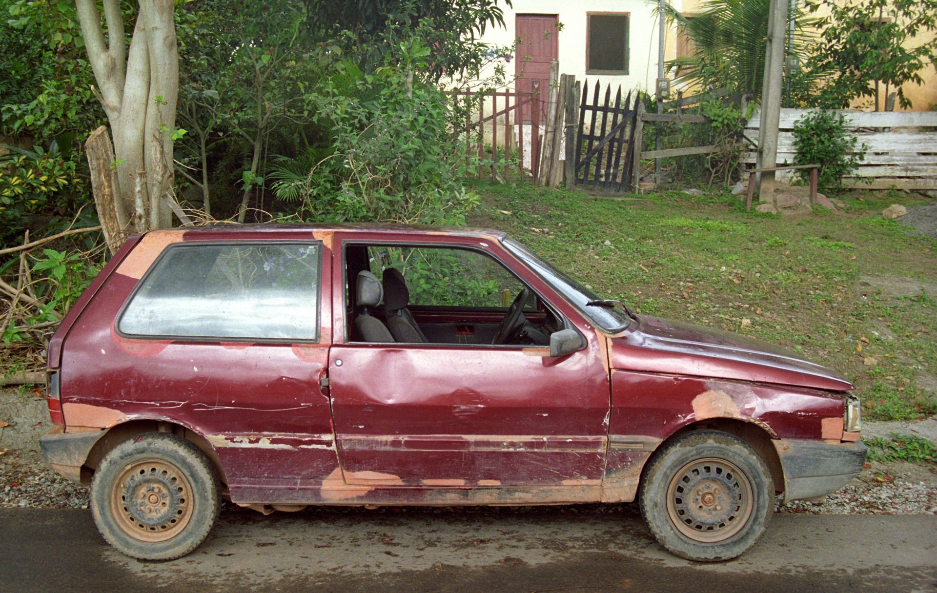 A red car is parked on the side of the road A red car is parked on the side of the road