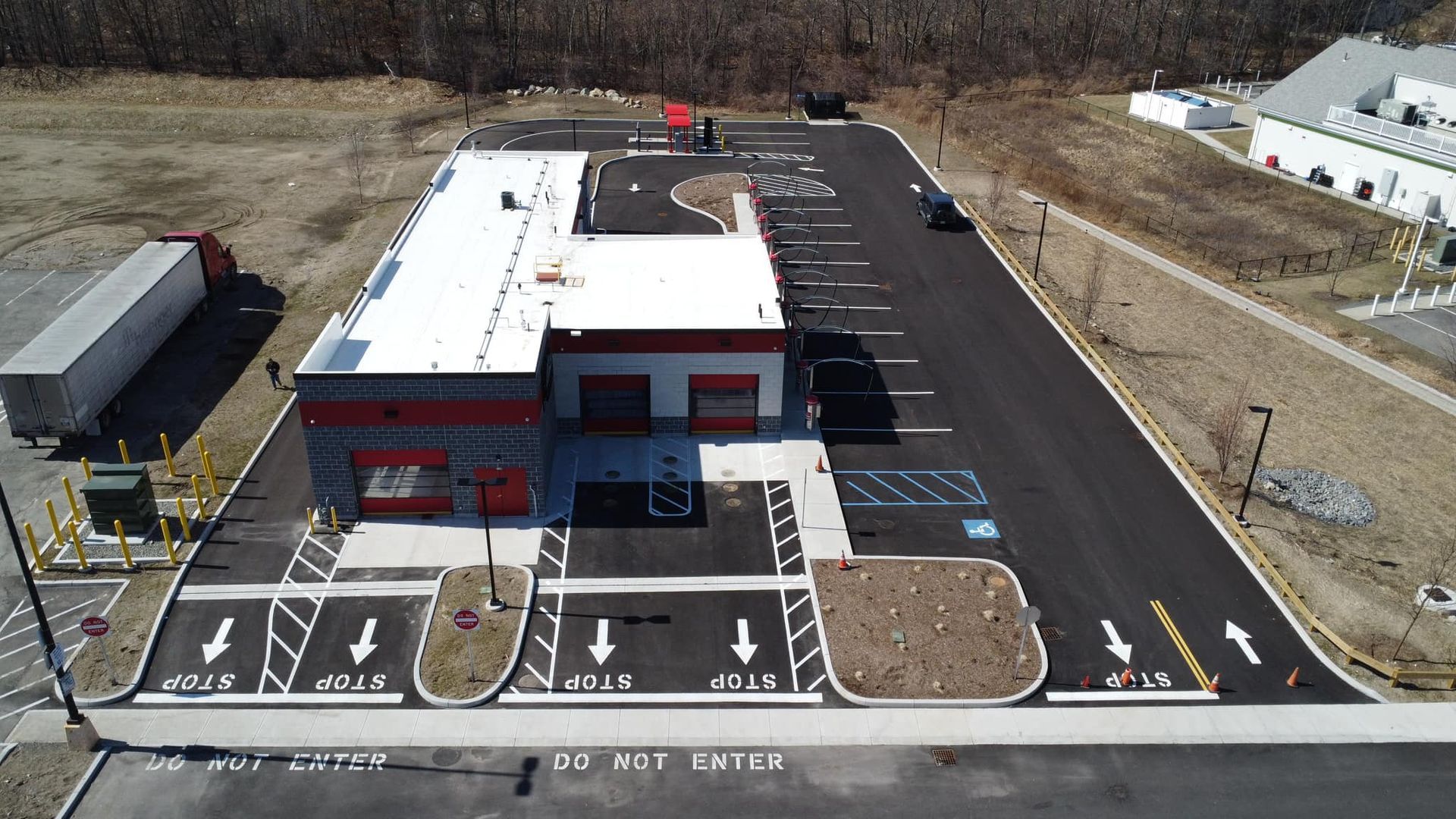 An aerial view of a parking lot with a building in the background