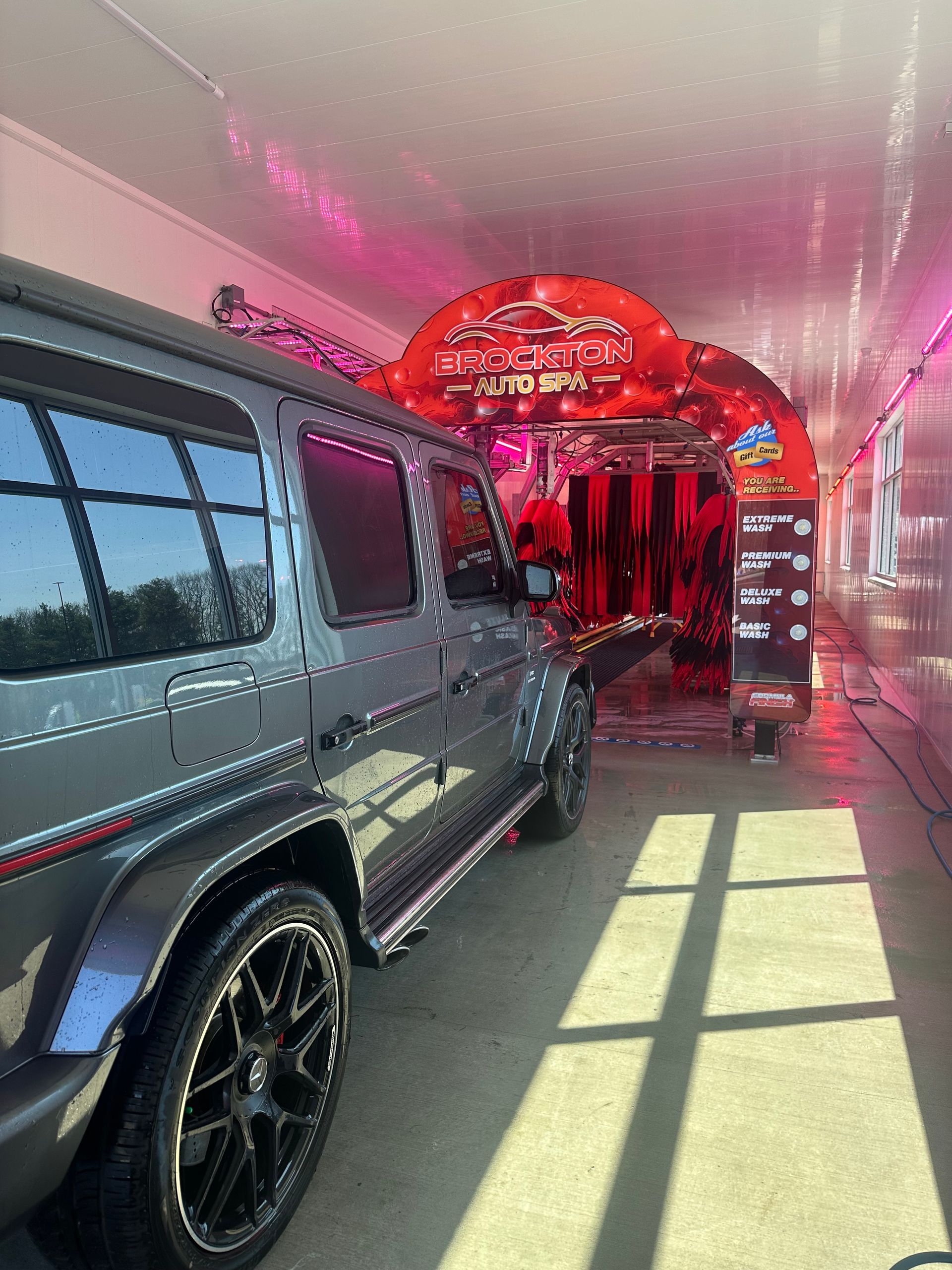 A gray suv is parked in a car wash.