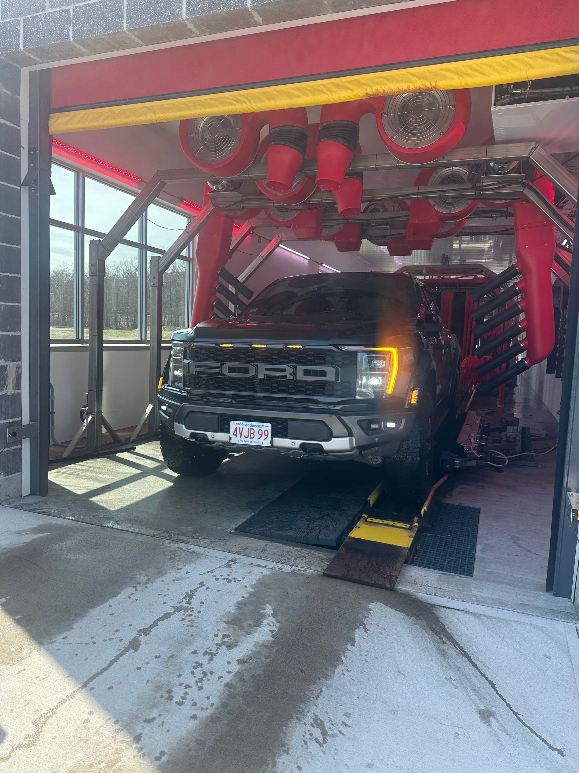A ford raptor is being washed in a car wash.