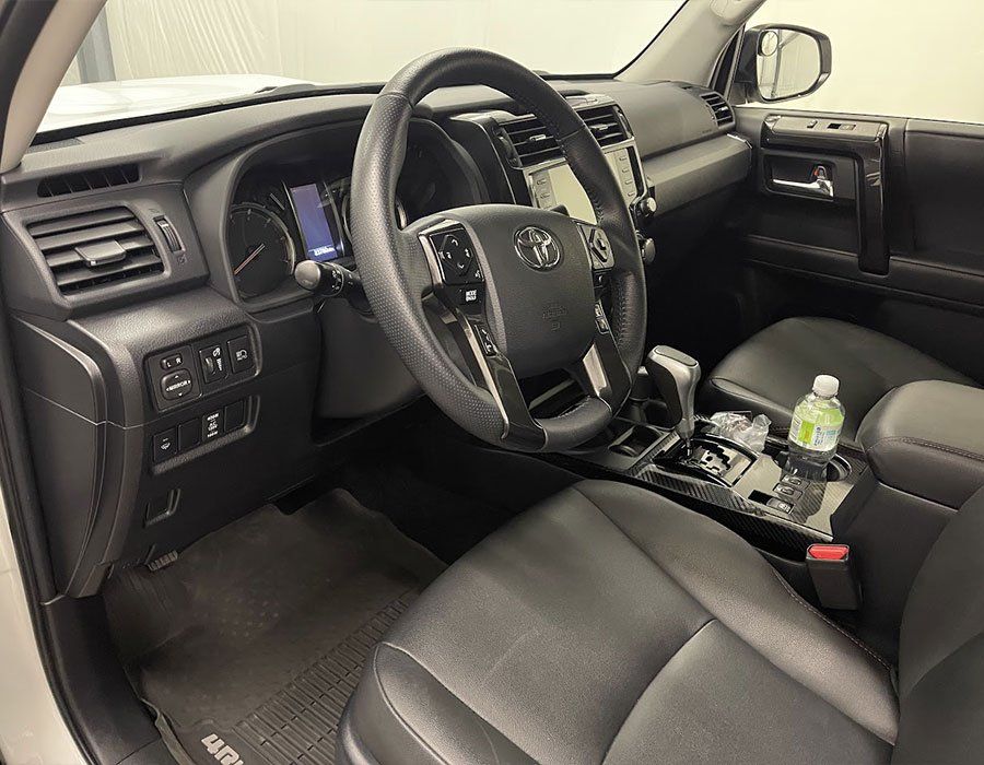 The interior of a toyota 4runner with a bottle of water in the center console.