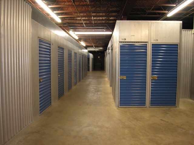 Storage containers with orange roll-up doors, in a paved lot. Storage containers with orange roll-up doors, in a paved lot.