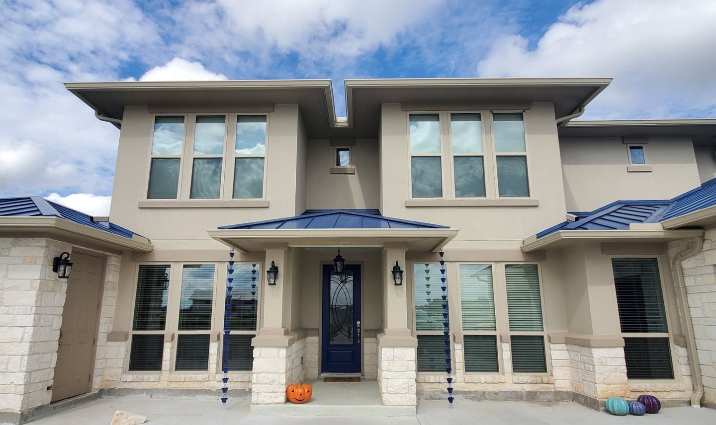 rain gutter installation in Austin with blue rain chains to match blue metal roof