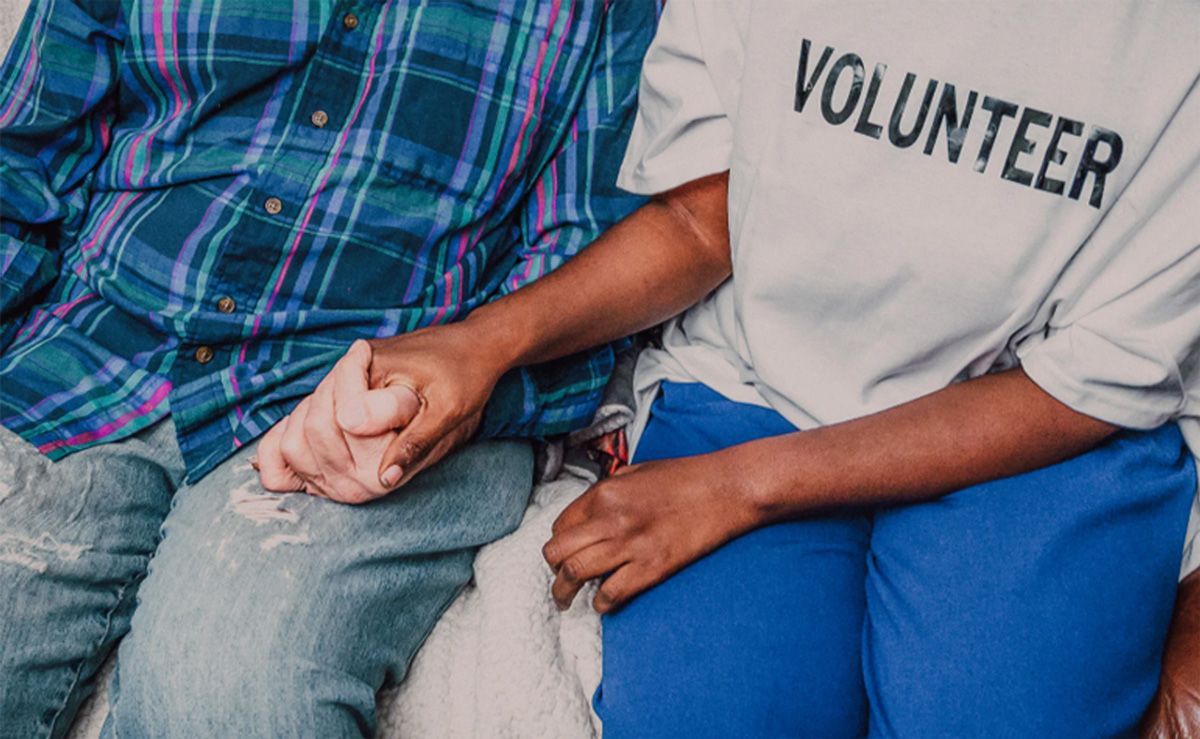 Two people sitting close together, holding hands