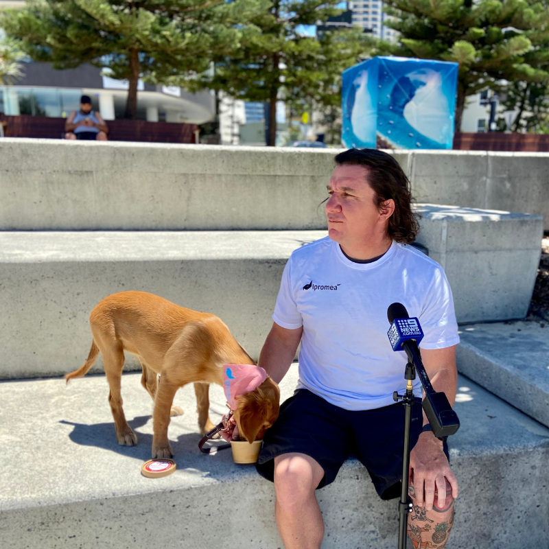 A man in a white shirt is sitting next to a dog