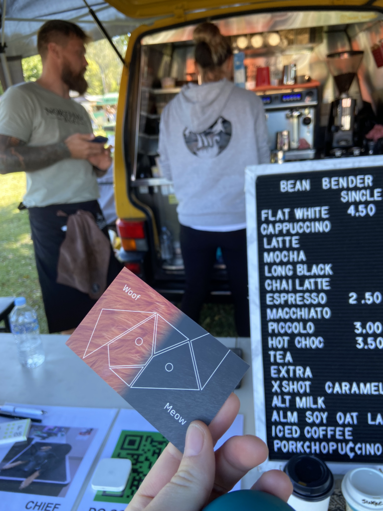 A person holding a card in front of a sign that says bean bender single