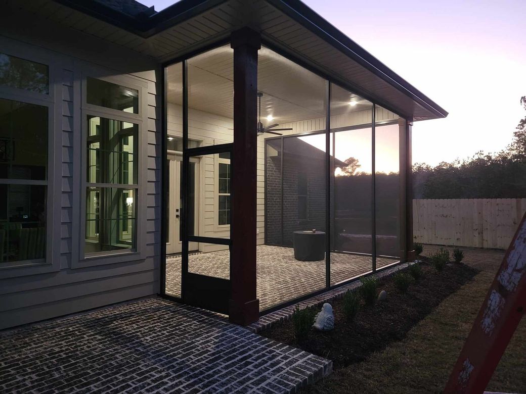 A screened in porch with a ladder in front of it