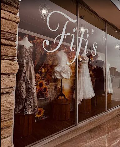Fifi's Bridal storefront with wedding dresses on display. Large window with white script lettering.