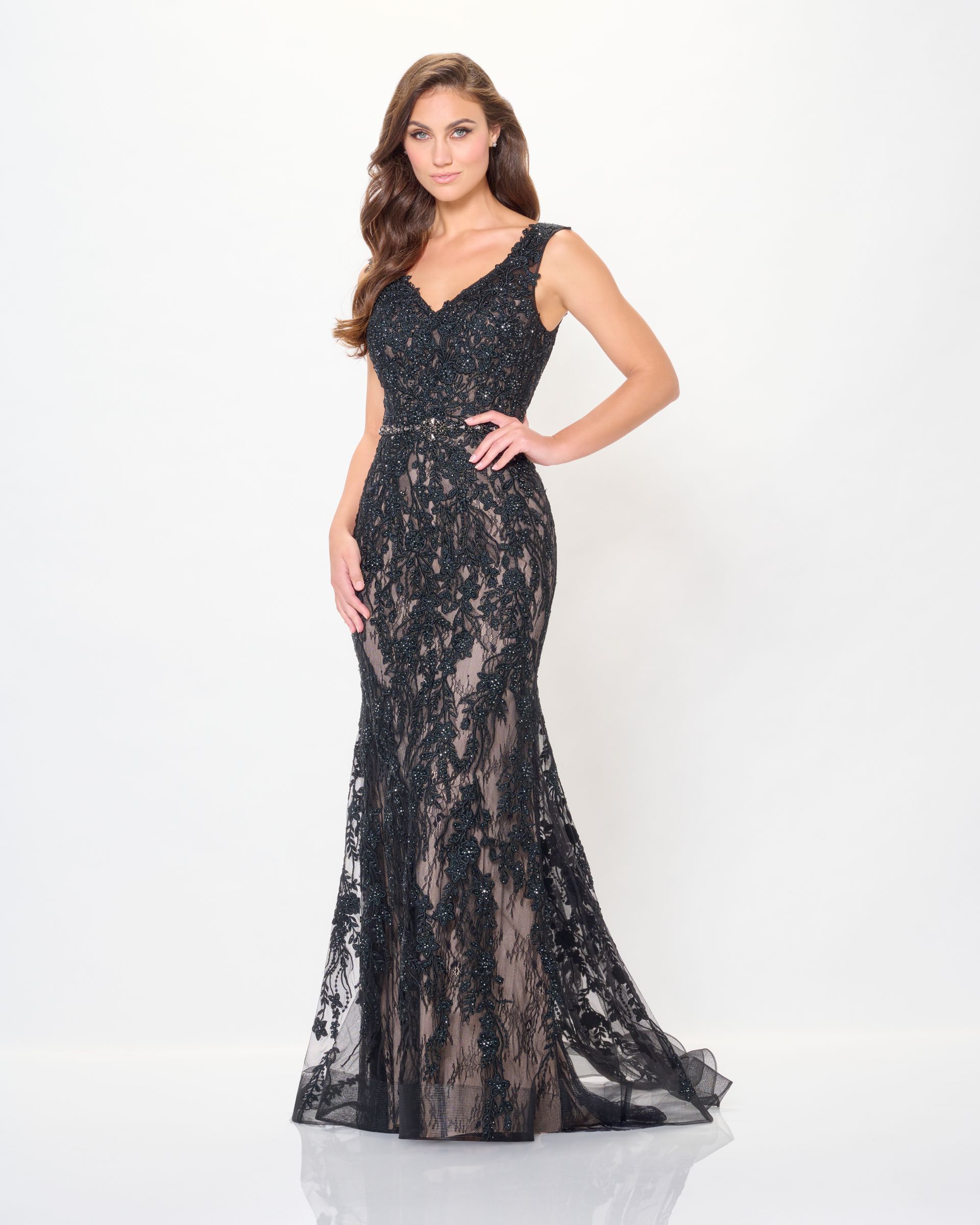Woman in a black, beaded, formal gown with a sweetheart neckline and mermaid silhouette, posing.