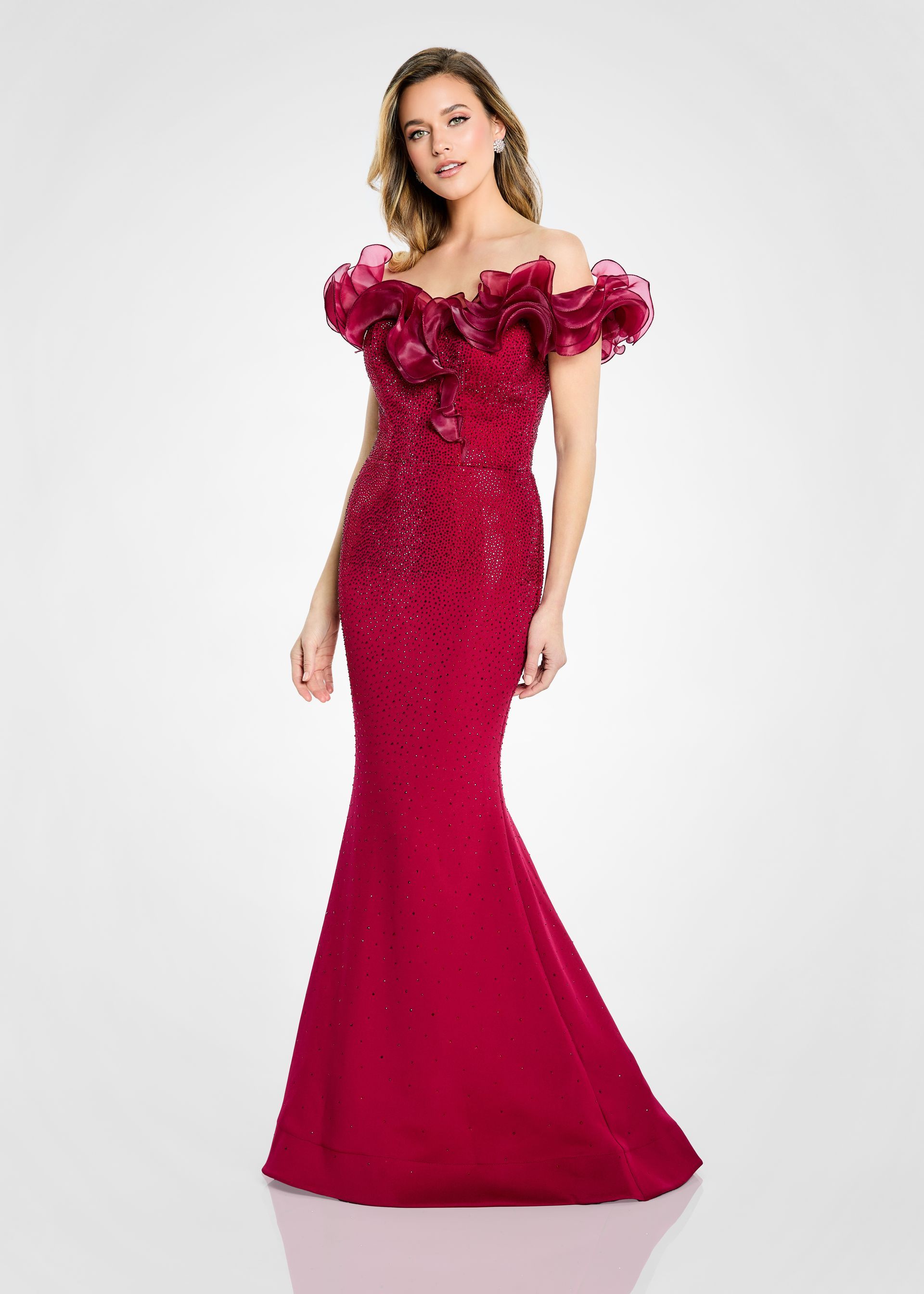Woman in a bright red sequined evening gown with ruffled shoulders, posing against a white background