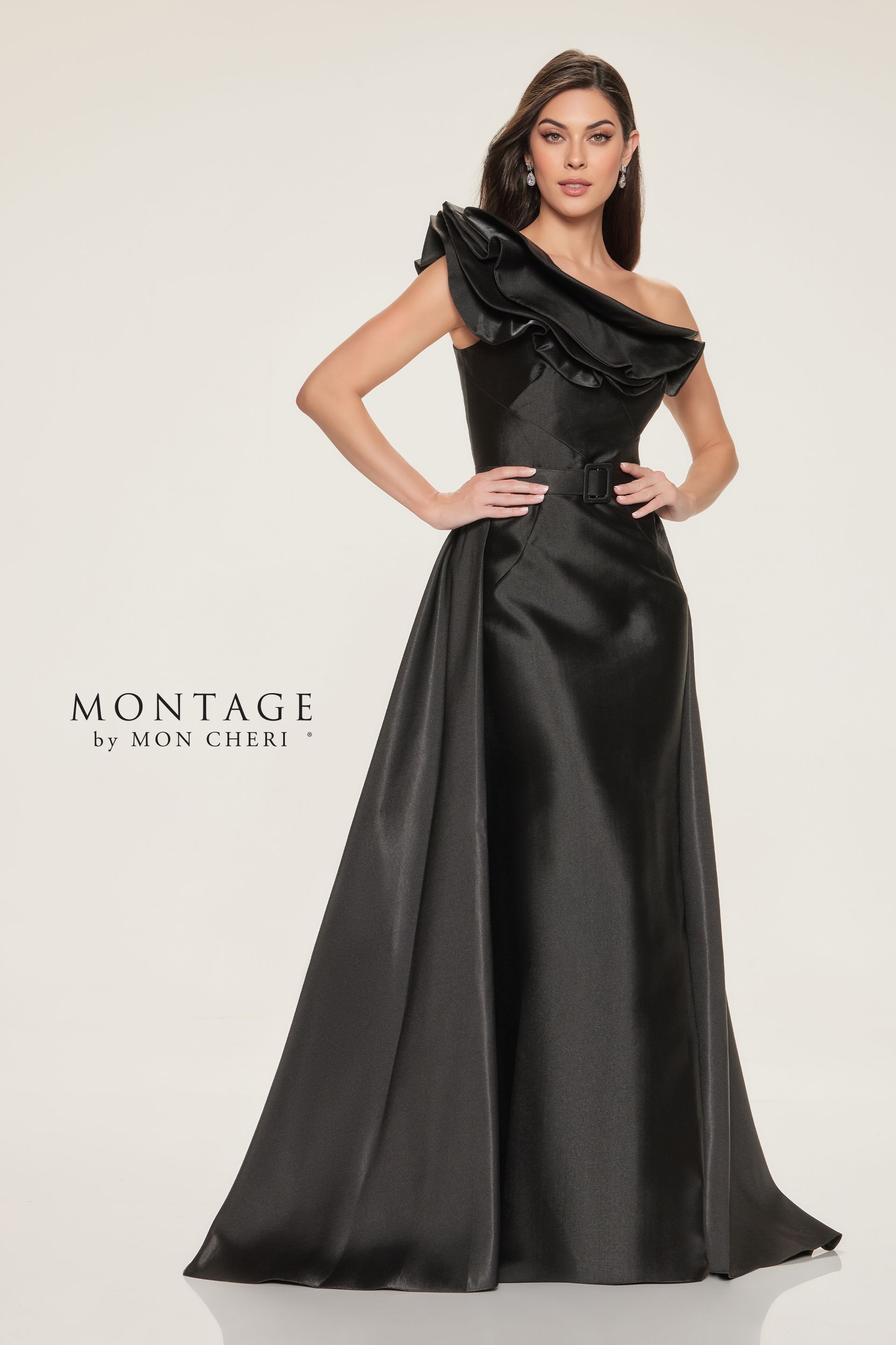 Woman in a black, one-shoulder evening gown with ruffled neckline and flowing skirt, posing.