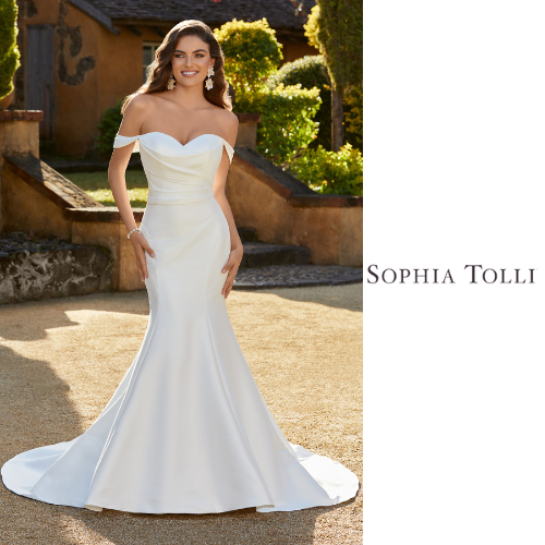 Woman in white off-the-shoulder wedding gown, smiling outside, with Sophia Tolli logo.