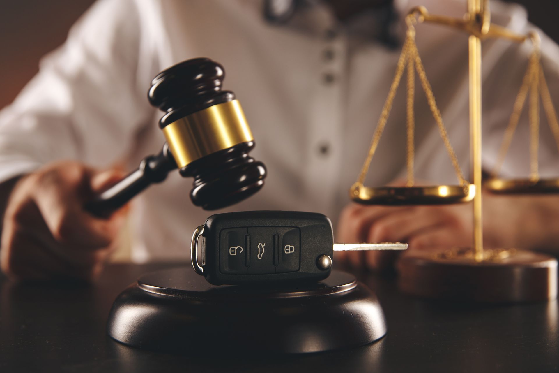 Gavel with car key on desk beside scales symbolizing legal support for car accident cases today now.