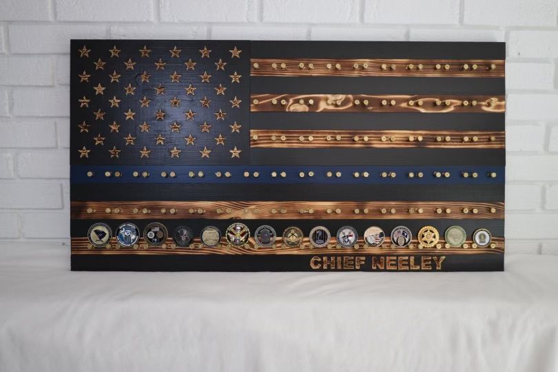 Wooden American flag with a blue line, decorated with coins, and the text 