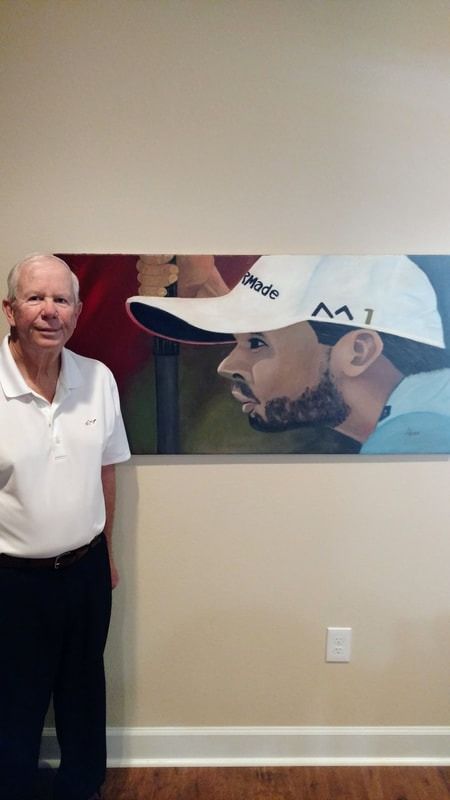 A man is standing in front of a large painting of a man wearing a hat.