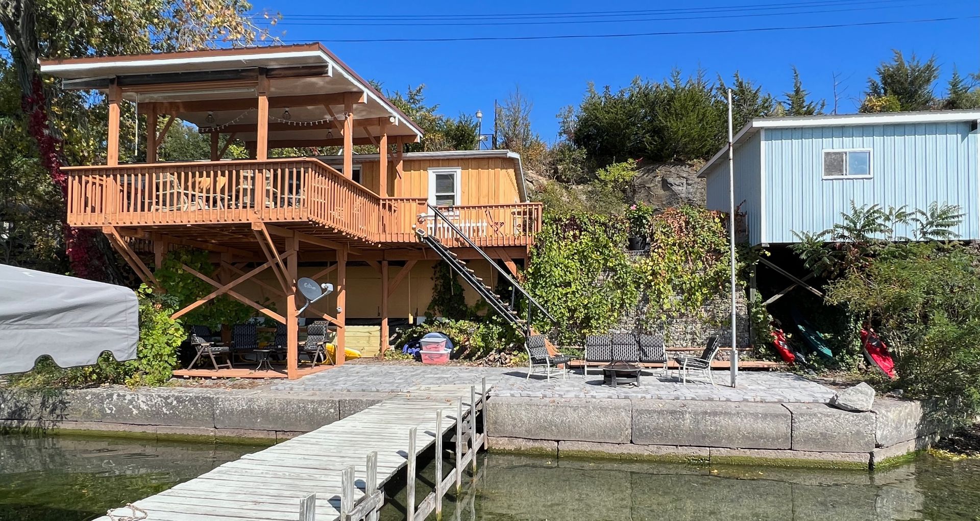 there is a dock in front of a house with a large deck .