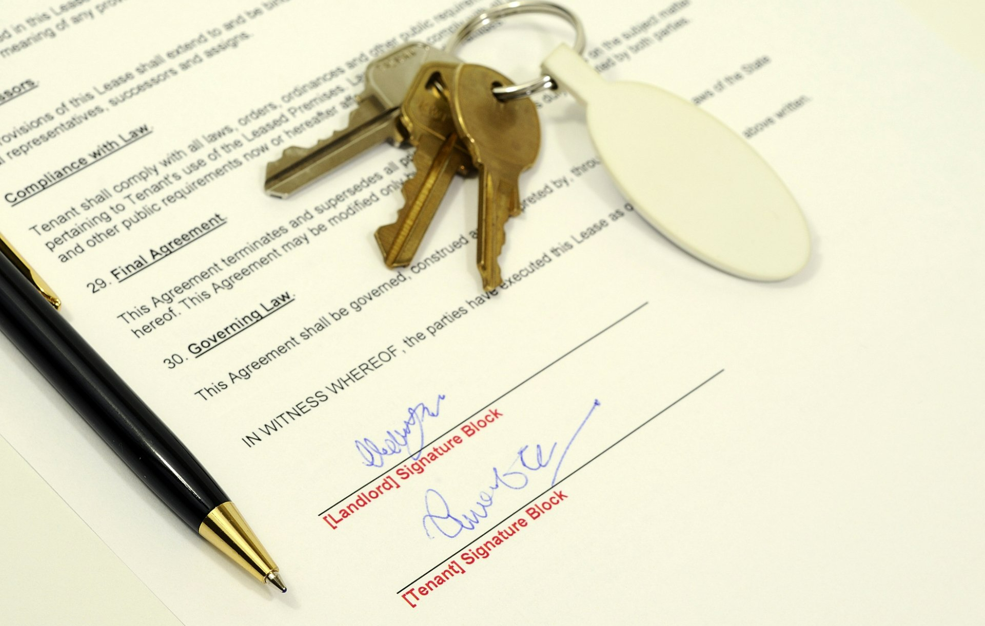 Keys, a pen, and signed lease agreement.