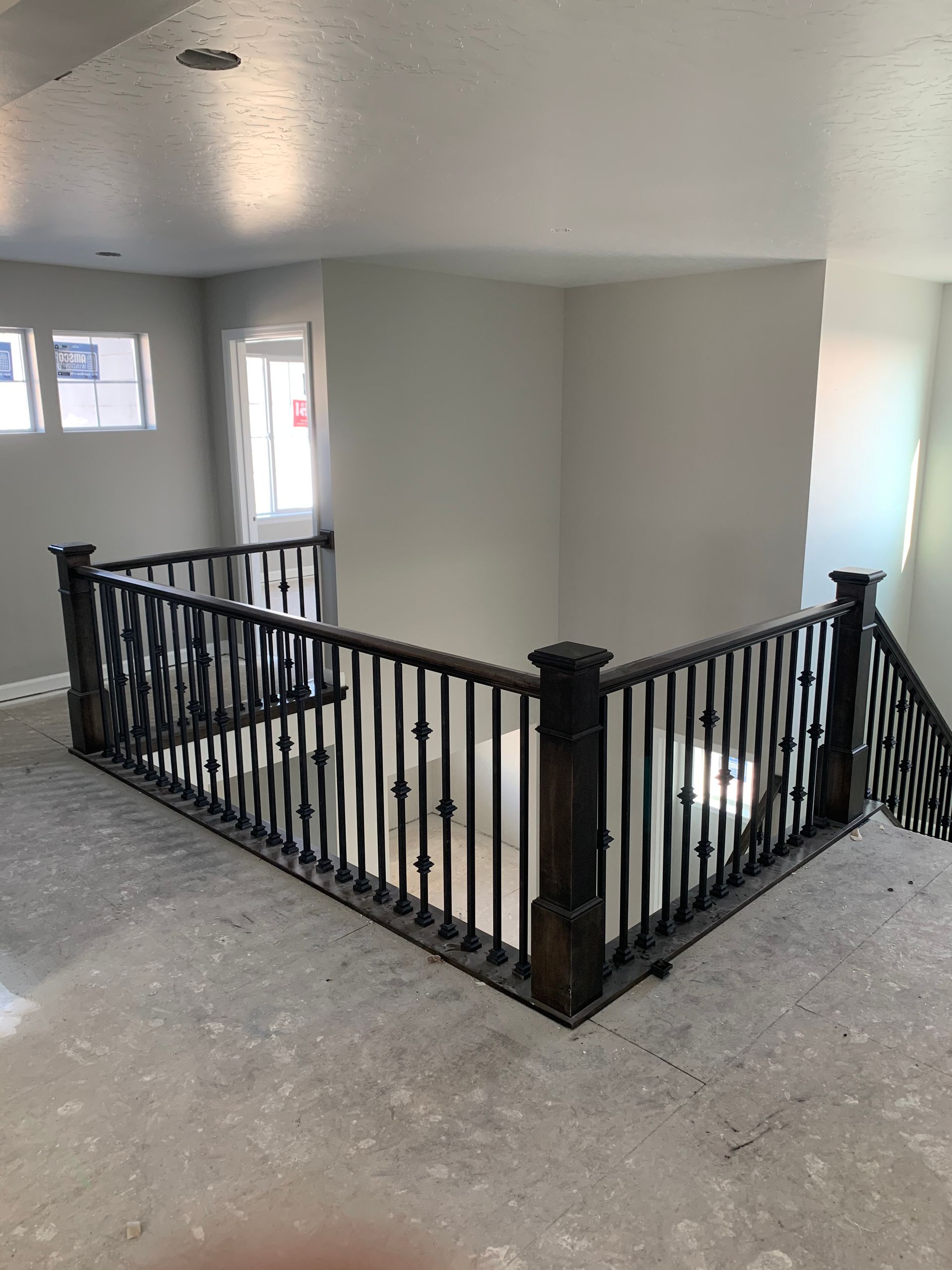 Interior view of a staircase with dark wooden handrails and spindles, newly built house.