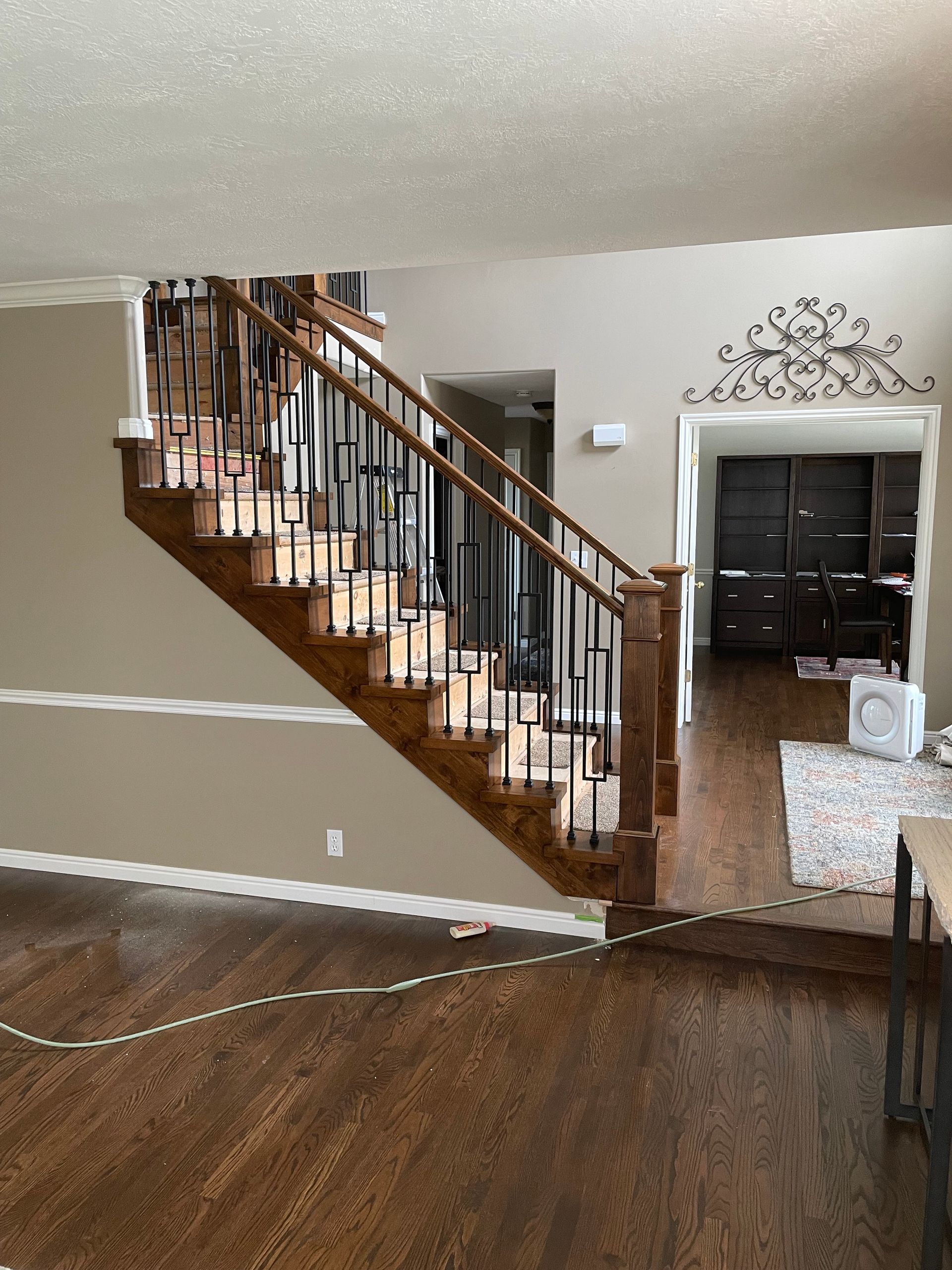 Wooden staircase with black metal railings in a home with hardwood floors.