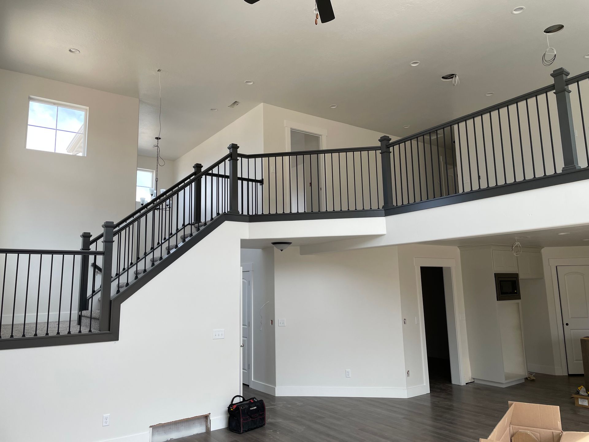 Interior view of a white room with a staircase featuring dark gray railings.