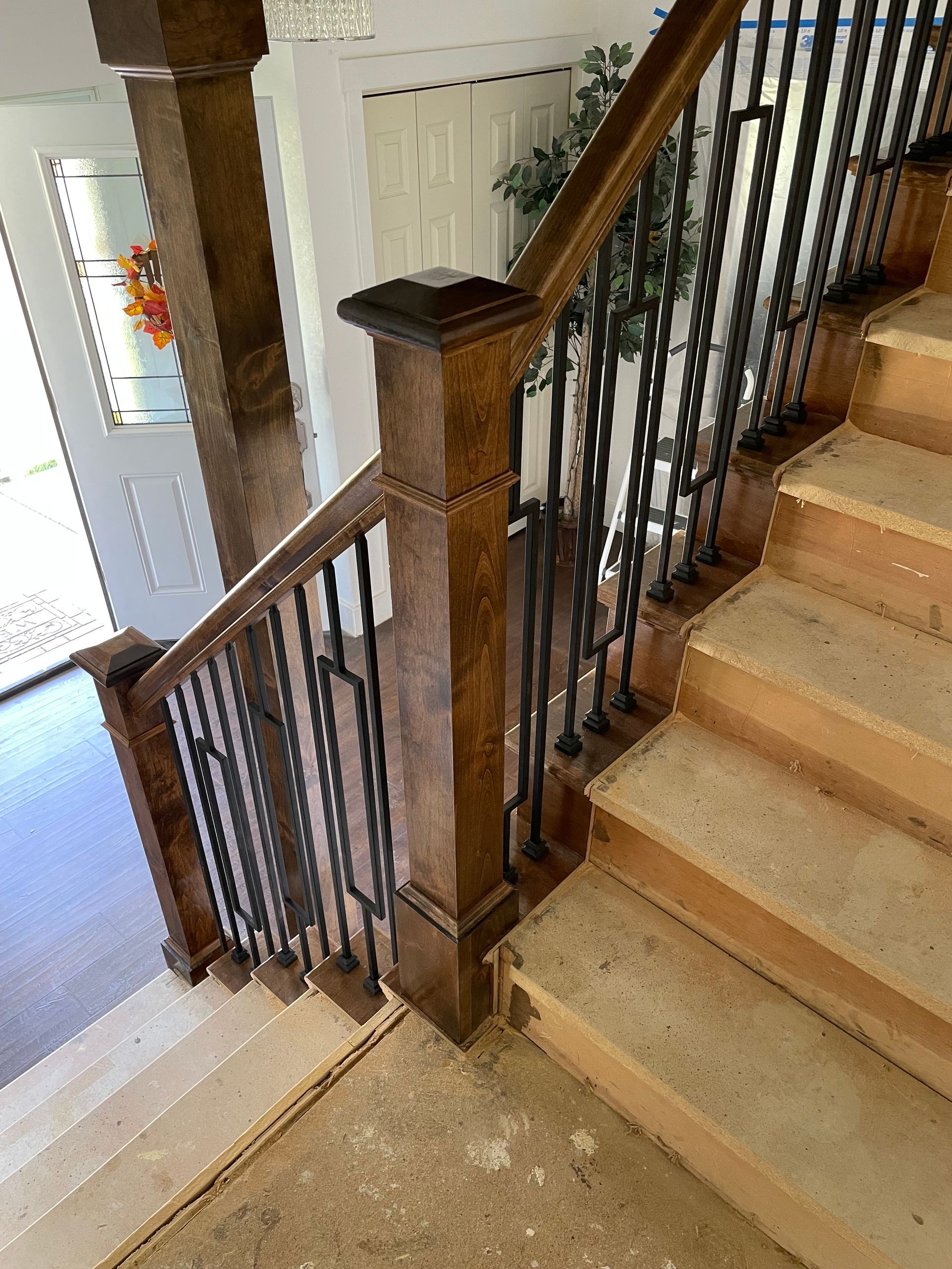 Wooden staircase with iron railings, leading downwards.