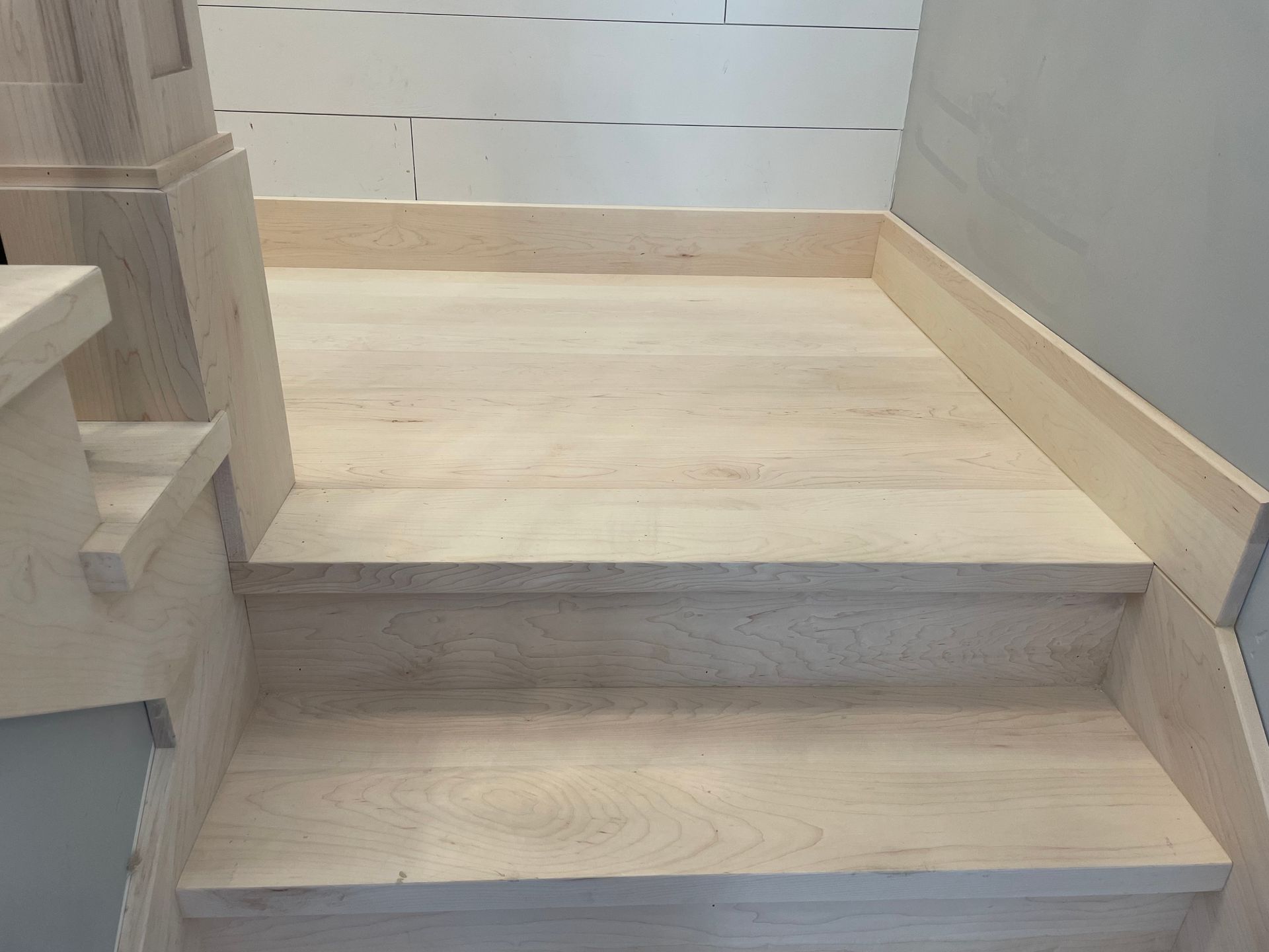 Wooden stairs leading up, light wood color, with a landing at top.