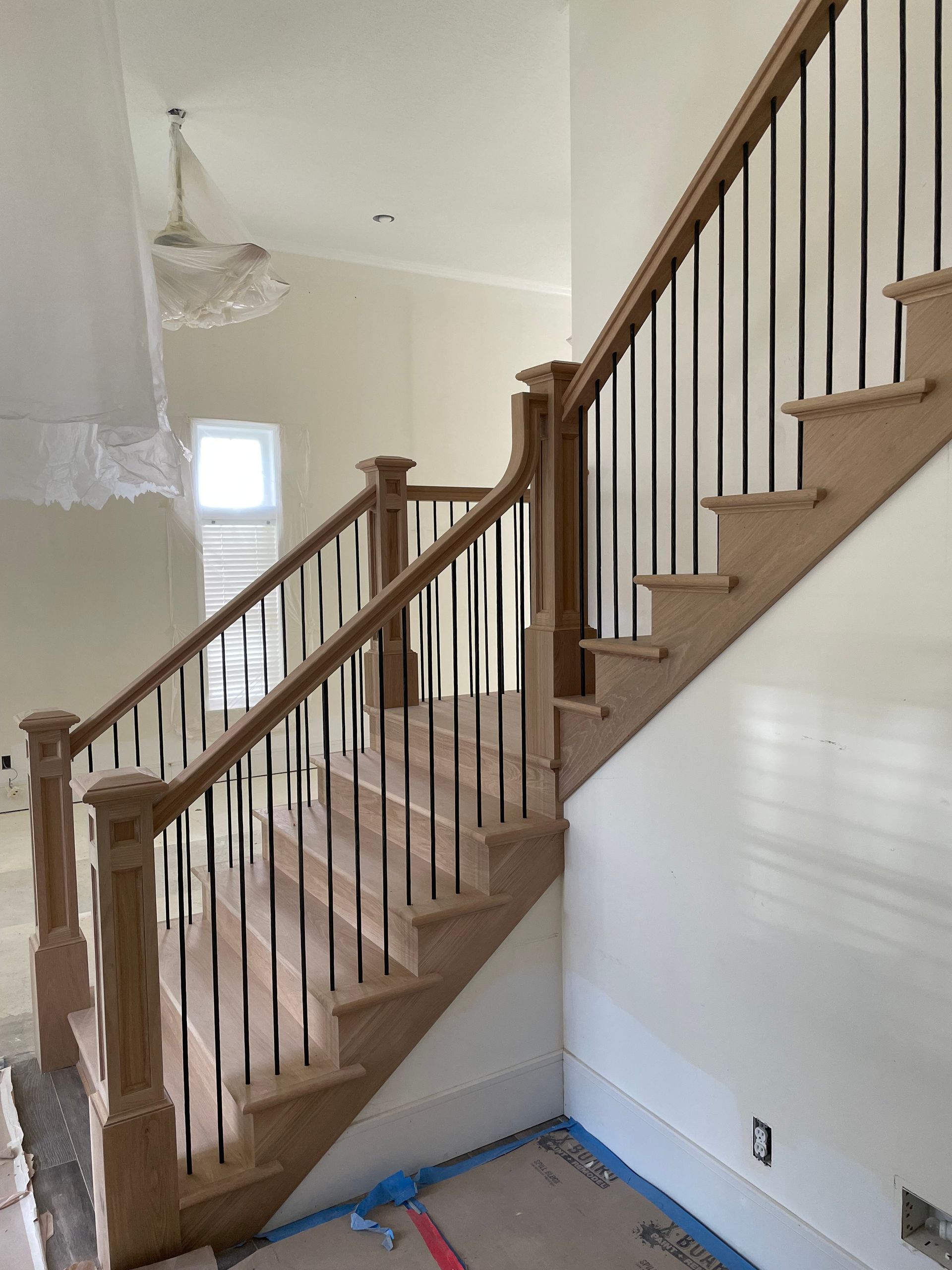 Wooden staircase with black metal balusters; interior shot.