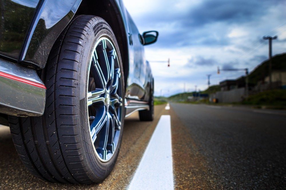 Black Car Tire on A Road with A White Line. Cloudy Sky — ATD Automotive in North Wollongong, NSW