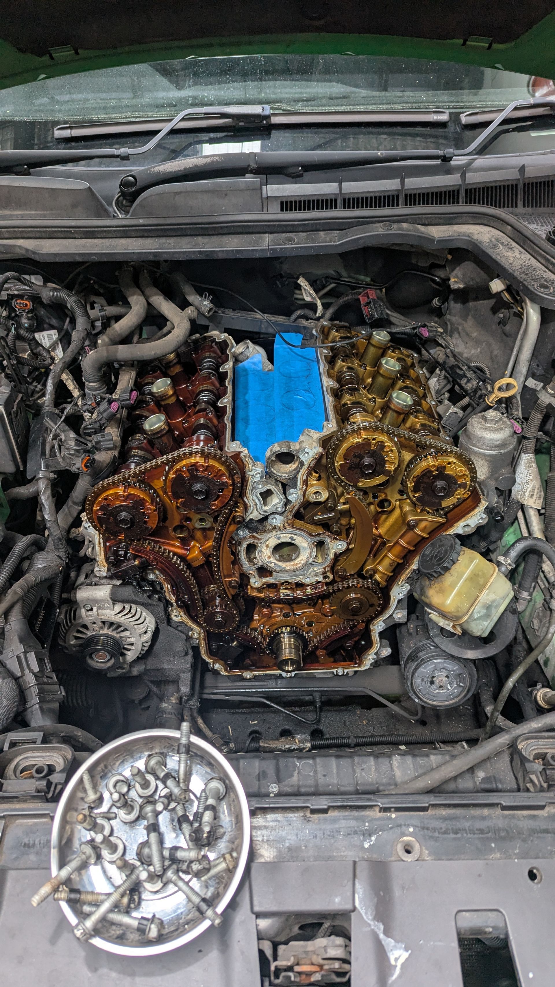 Engine bay with disassembled engine components, showing oil and a blue part  — ATD Automotive in North Wollongong, NSW